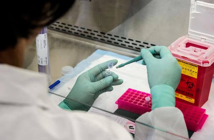 gloved hands doing lab work